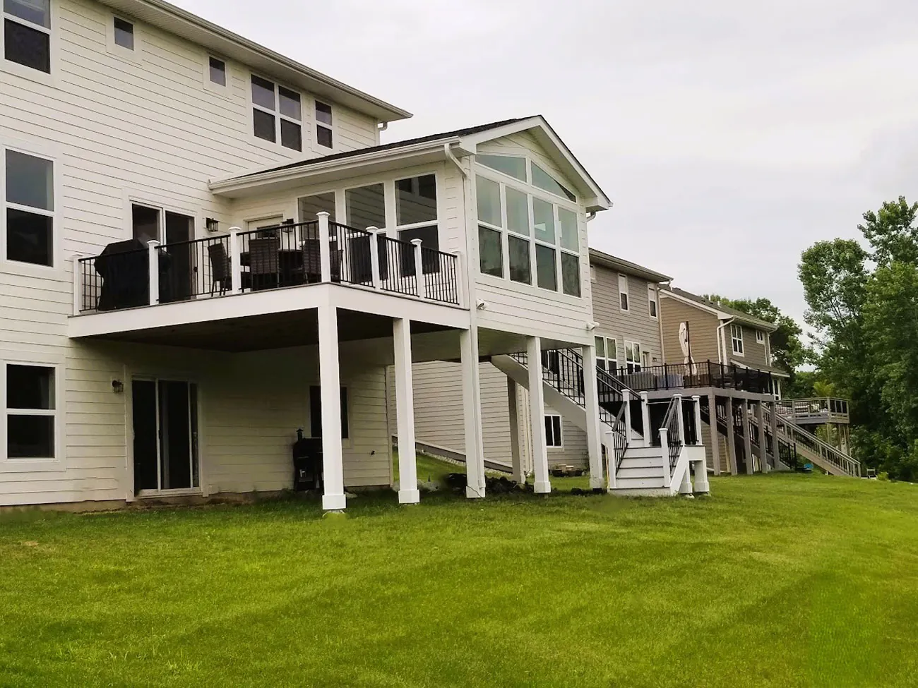 Two-storey home addition with deck by BN Builders