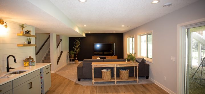 Sleek and modern basement renovation featuring an open floor plan with kitchenette, entertainment area, and stylish decor.