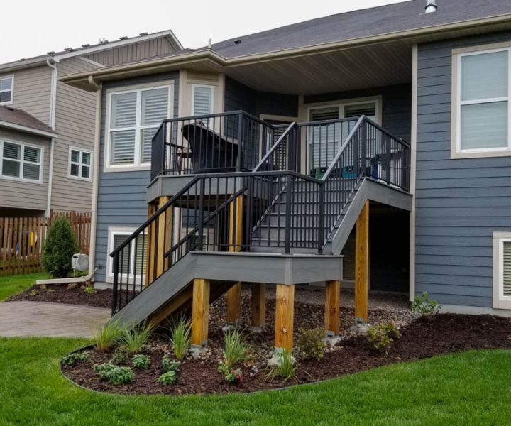 A modern home showcasing an elevated wooden deck with stylish outdoor furniture, ideal for family gatherings and enjoying the outdoor ambiance.